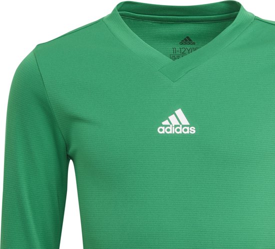 Close-up van de V-hals en wit Adidas-logo op een groen sportshirt.