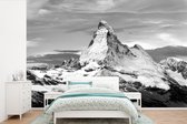 Behang - Fotobehang Wolken boven de Matterhorn in Zwitserland - zwart wit - Breedte 420 cm x hoogte 280 cm