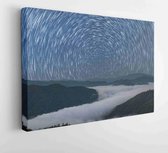 Canvas schilderij - Star trails on the mountain in mist in the countryside of northern Thailand, Star circles above the night mountain forest.  -      1927687661 - 50*40 Horizontal