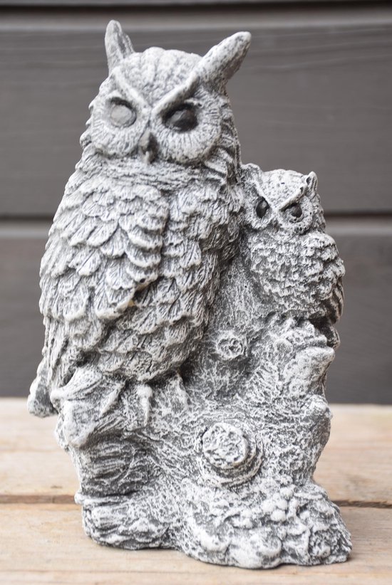 Gedetailleerd grijs beeldje van een uil met twee jongen, focus op de uil.