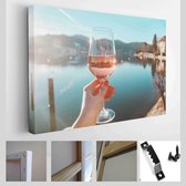 Vrouwelijke hand met glas wijn. Gezellige pier aan de kust van het meer Tegernsee. Alpine bergen in Beieren (Bayern) - Modern Art Canvas - Horizontaal - 1329176453