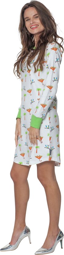 Wit nachthemd met lange mouwen, bedrukt met apen en palmbomen. Groene boorden. Gedragen met zilverkleurige hoge hakken.