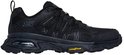 Zijkant van een zwarte Skechers wandelschoen met Goodyear zool en zichtbare luchtdemping.