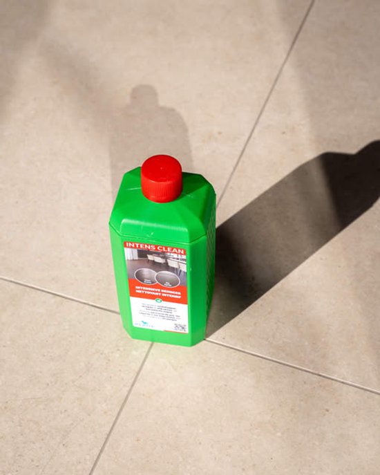 Groene fles met rode dop, etiket met "INTENS CLEAN". Staat op een lichte tegelvloer met schaduw.