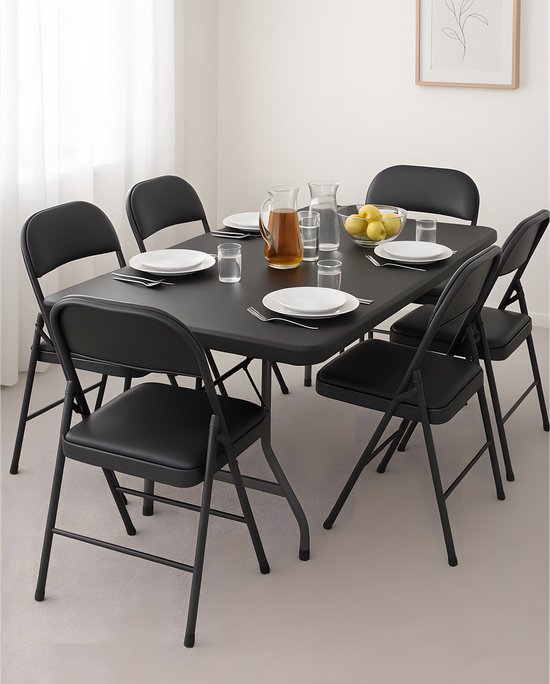 Zwarte klaptafel met 6 zwarte stoelen, gedekt met borden en glazen.