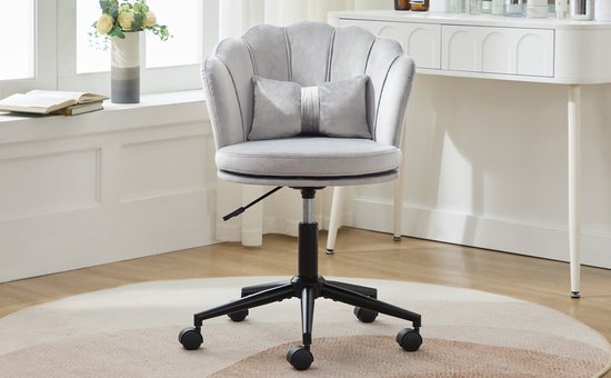 Fauteuil en velours gris avec dossier en forme de pétale et coussin nœud, dans un intérieur de chambre.