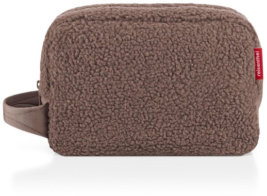 Bruine teddy toilettas met draagriem en rood reisenthel-label op een witte achtergrond.