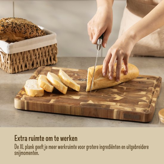 Une planche à découper Namture en bois XL avec un pain en cours de découpe. Un panier à pain est à l'arrière-plan.