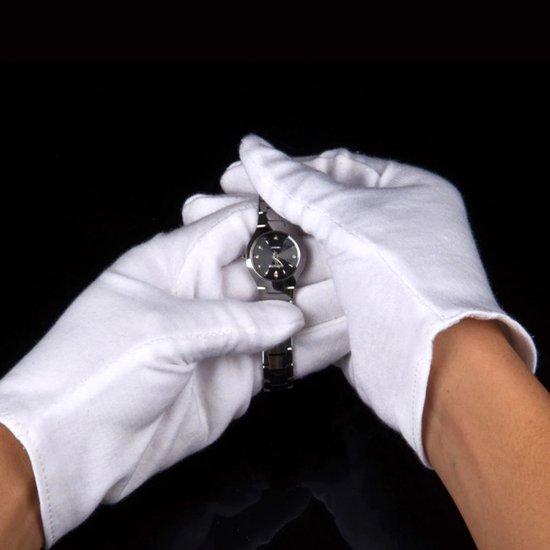Witte handschoenen houden een zilverkleurig horloge met zwarte wijzerplaat vast.