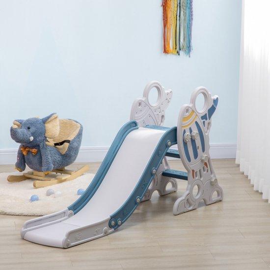 Een blauw-grijze glijbaan staat op een zachte vloer in een kinderkamer, naast een grijze olifant schommelstoel.