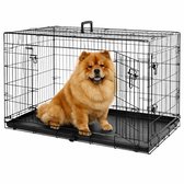 Een bruine chowchow zit in een open zwarte metalen hondenbench.