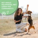 Vrolijke vrouw traint haar hond buiten met gedroogde vleessnacks.