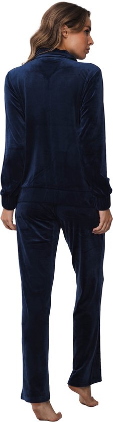 Achterkant van een vrouw in een donkerblauw velours huispak met rits. De set bestaat uit een vest en een lange broek.