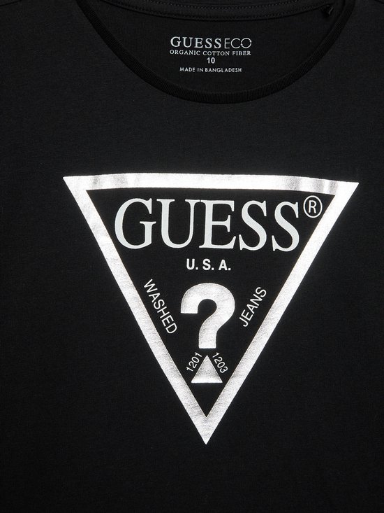 Detail van het witte Guess driehoek logo op een zwart Guess Eco T-shirt met lange mouwen.