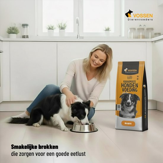 Een vrouw en een Border Collie in een keuken. De hond eet uit een voerbak. Naast hen staat een zak hondenvoer. Tekst: Smakelijke brokken die zorgen voor een goede eetlust.
