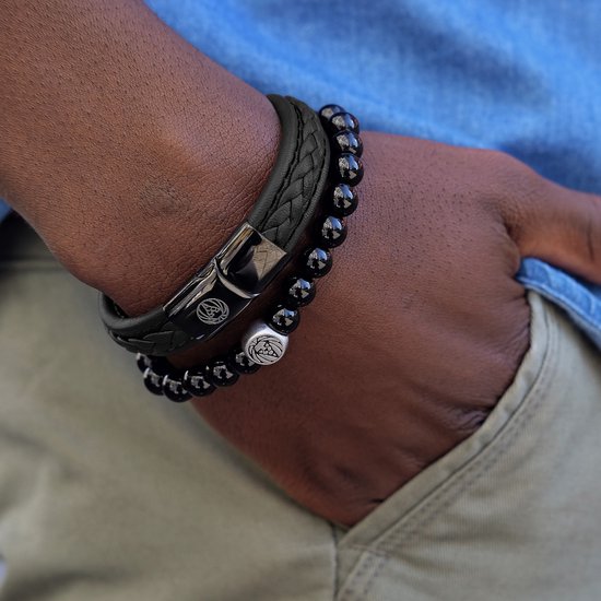 Zwarte gevlochten leren armband met een zilverkleurig gespsluiting met leeuwenlogo.