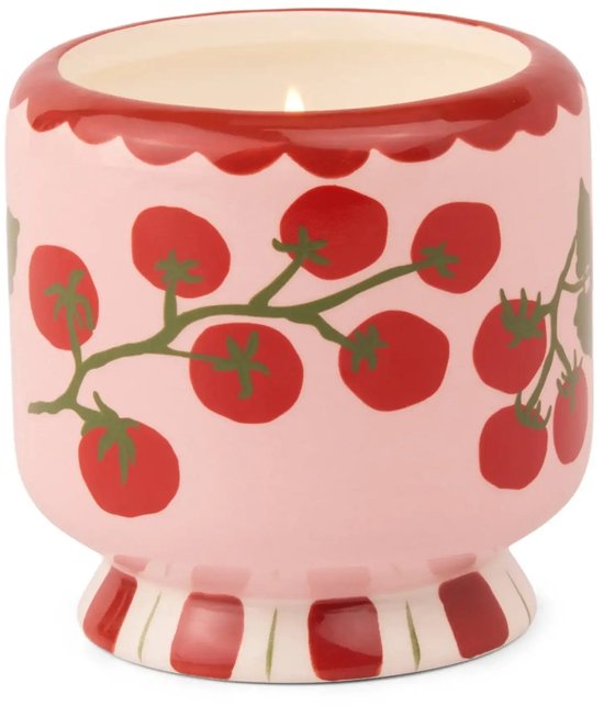 Roze keramische kaars met tomatentakjes en golfachtige rode rand, brandende lont.