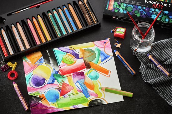 STABILO woody 3 in 1 ARTY potloden in een doos, naast een aquareltekening en losse potloden.