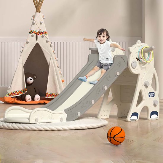 Kindje glijdt op een grijze en witte eenhoorn glijbaan met ringgooi spel en basketbal.