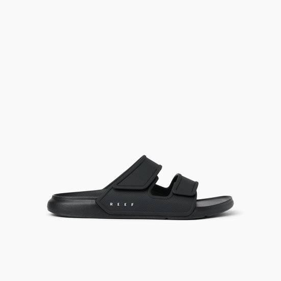 Zwarte Reef slippers met twee klittenbandsluitingen en een reliëfpatroon op de banden.