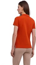 Vrouw in oranje poloshirt met korte mouwen, beige broek en gouden oorbellen, van achteren gezien.