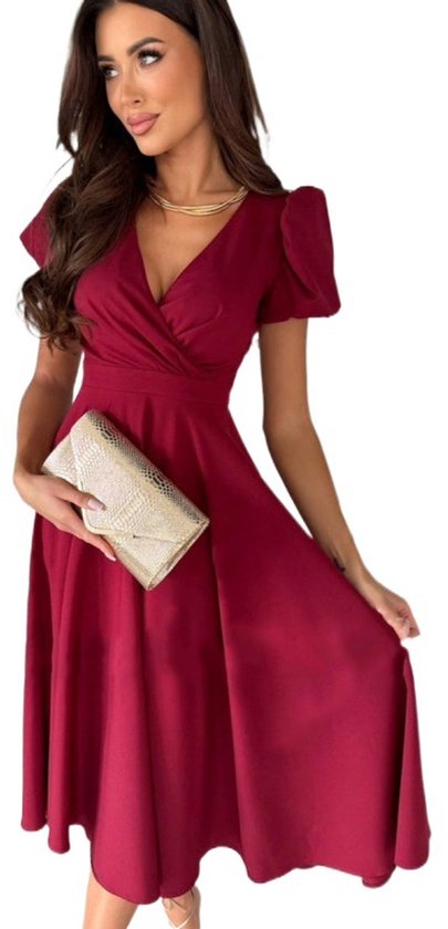 Donkerrode galajurk met V-hals, pofmouwen en een volle rok. Model houdt een gouden clutch vast.