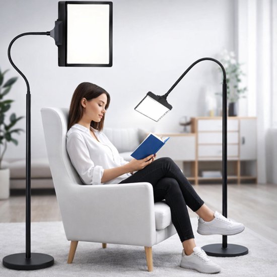 Een vrouw leest een boek in een fauteuil, verlicht door een staande loeplamp.