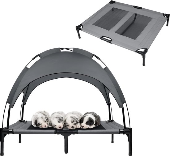 Quatre chiots dorment sur un lit surélevé gris pour chien avec auvent.