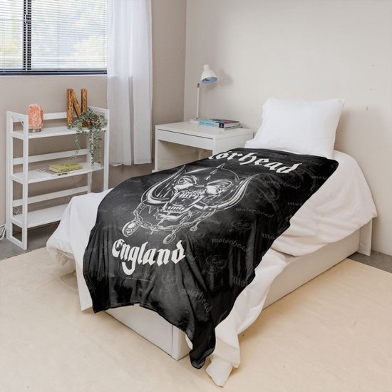 Zwarte deken met de Motörhead 'Snaggletooth'-logo's en de tekst 'England' in witte gotische letters op een eenpersoonsbed.