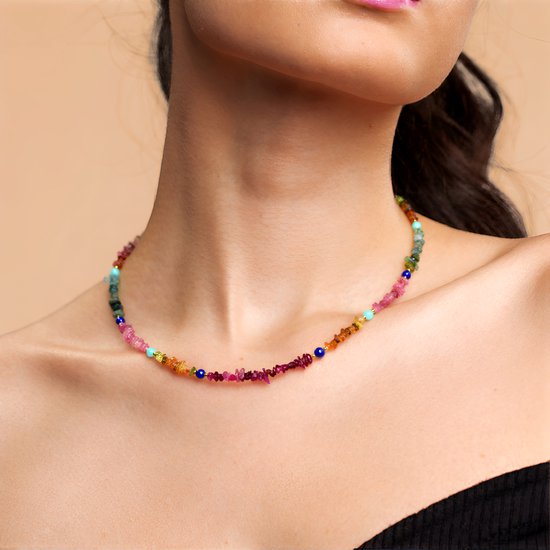 Multicolor toermalijn en lapis lazuli ketting gedragen door een model met een diep decolleté.