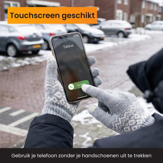 Grijze handschoenen met Noors patroon in gebruik op een smartphone.