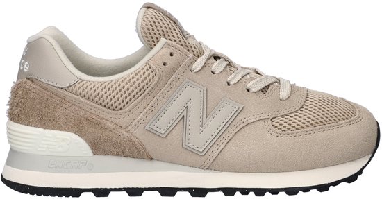 Zijzicht van een beige New Balance 574 dames sneaker met beige veters en logo.