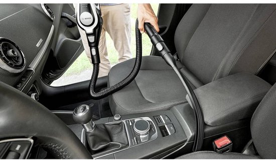 Persoon die de Bosch stofzuiger gebruikt om een auto schoon te maken.