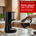 Une cafetière Tomado verse du café dans une tasse. La verseuse a une capacité de 1,25 litre.