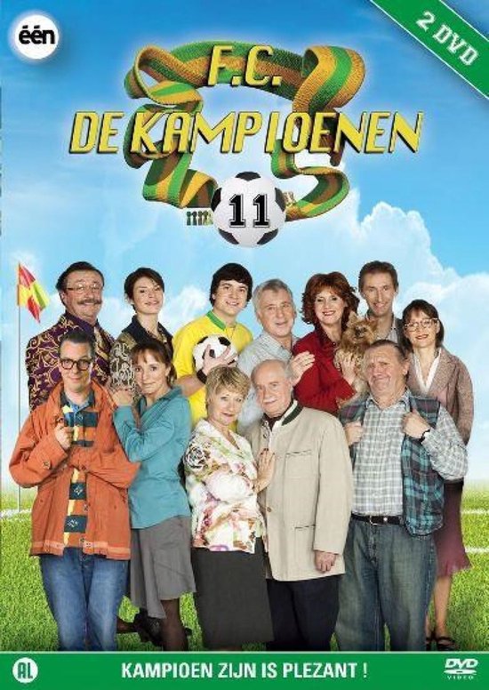 Groep van 11 personen, met "F.C. DE KAMPIOENEN" logo en voetbal, in veld met gras.