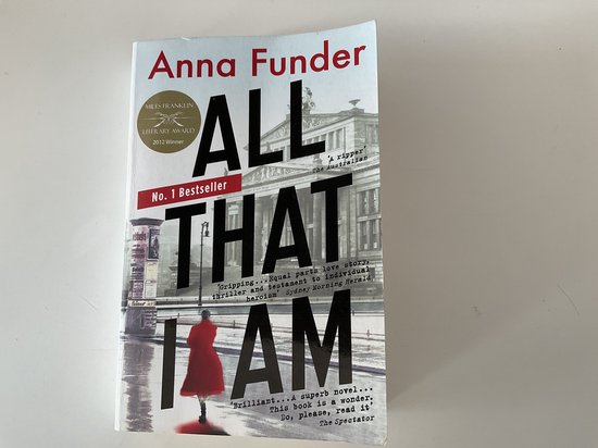Boekomslag van 'All That I Am' door Anna Funder met een vrouw in een rode jas op een straat achtergrond.