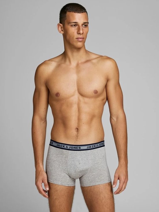 Man in grijze Jack & Jones trunks met zwarte band met logo.