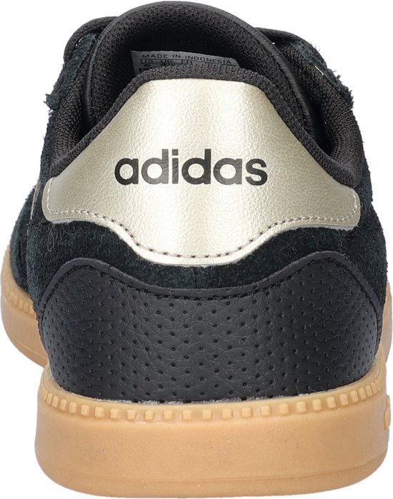 Achterkant van een zwarte Adidas sneaker met gouden hielstuk en perforaties.