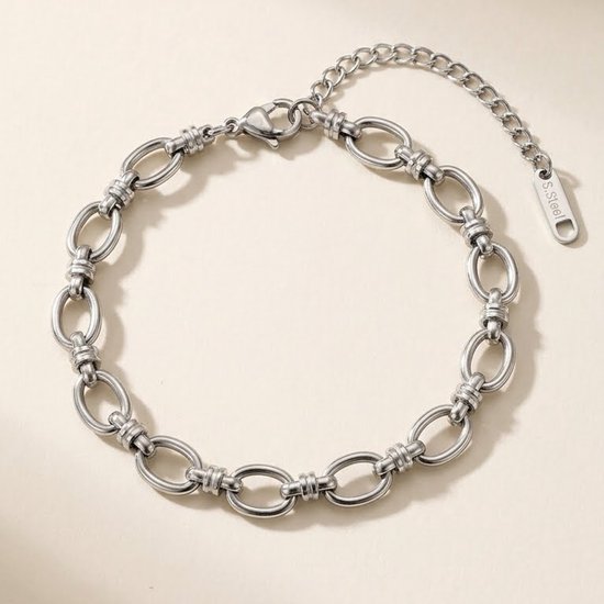 Bracelet à maillons argenté avec maillons torsadés et une étiquette 'S.Steel'.