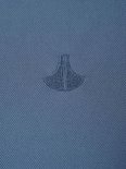 Detail van een geborduurd ankerlogo op een blauw poloshirt.
