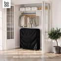 Bodo opvouwbaar bed in zwarte beschermhoes, opgeborgen in een kast. De hoes beschermt tegen stof.