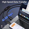 Zwarte USB-C kabel voor 480 Mbps gegevensoverdracht tussen laptop en telefoon.