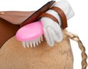 Close-up van de rug van een lichtbruin pluche paard met een bruine zadel. Een roze borstel zit aan het zadel bevestigd.