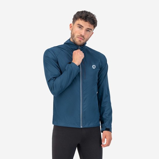 Man in blauwe Rogelli hardloopjas met rits en logo. Grijze opdruk 'ROGELLI' op de nek.