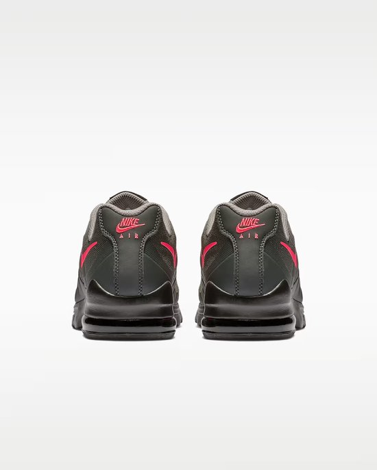 Achterkant van grijze Nike Air Max Invigor sneakers met roze logo's.