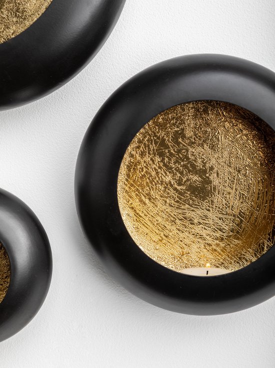 Trois bougeoirs muraux ronds noirs avec intérieur doré.