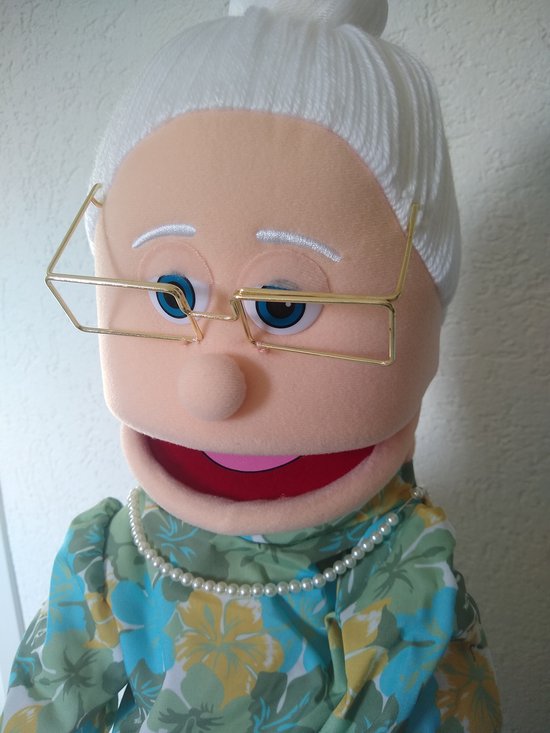 Grootmoeder handpop met witte haren in een knot, bril, parelketting en bloemenjurk.