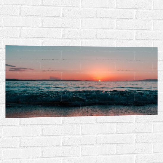 WallClassics - Muursticker - Rustieg Golf op Strand bij Zonsondergang - 100x50 cm Foto op Muursticker