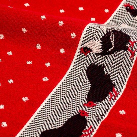 Tissu rouge à pois blancs avec une bordure de coqs noirs sur un motif chevrons noir et blanc.