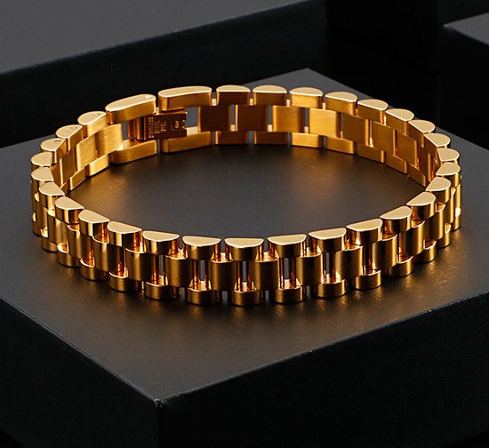 Gouden schakelarmband met een glanzende afwerking, op een zwarte doos.